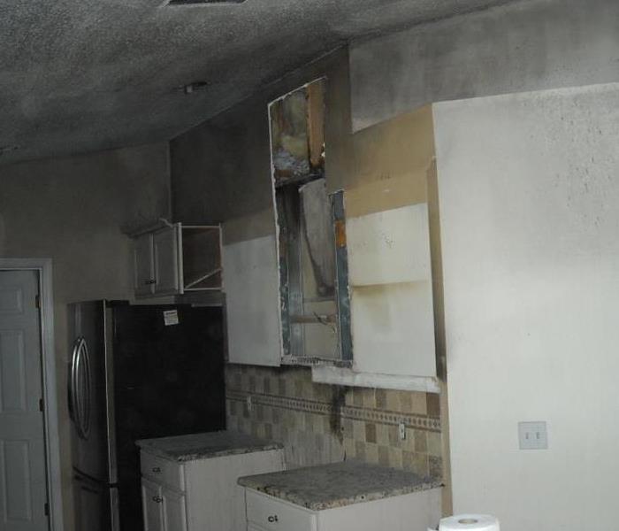 a fire occurred in this kitchen and there is soot along walls and ceiling. 
