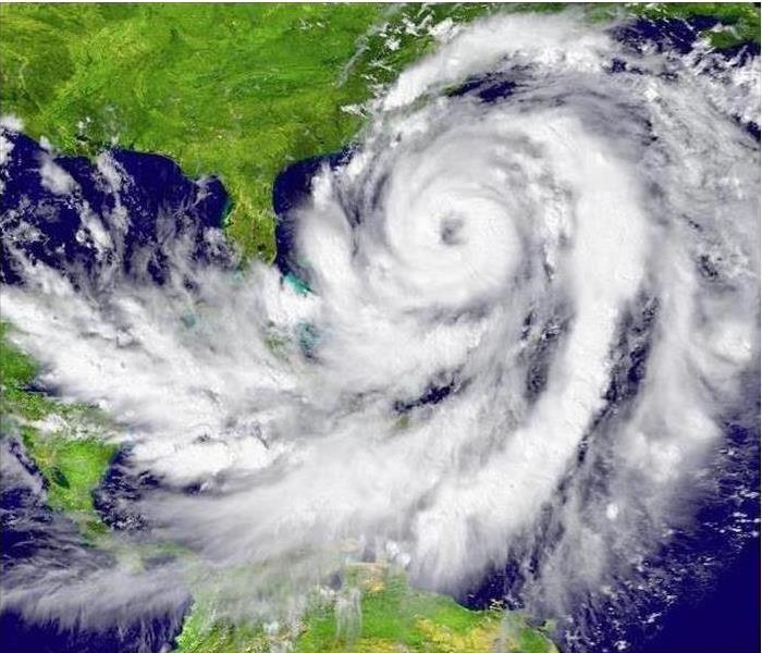 a picture of a hurricane that is taken from the angle of space where it is covering Florida, and heading up the Atlantic. 